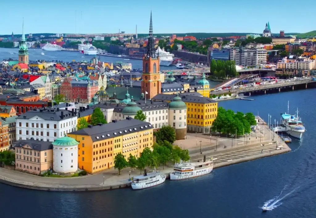 Aerial view of Stockholm cityscape showing iconic buildings, vibrant architecture, and boats along the waterfront, perfect for exploring Swedish culture and history.