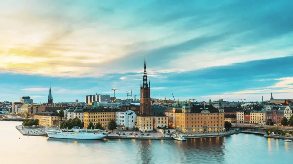 Stockholm skyline at summer evening showcasing Riddarholm Church and colorful buildings along the waterfront, Sweden.