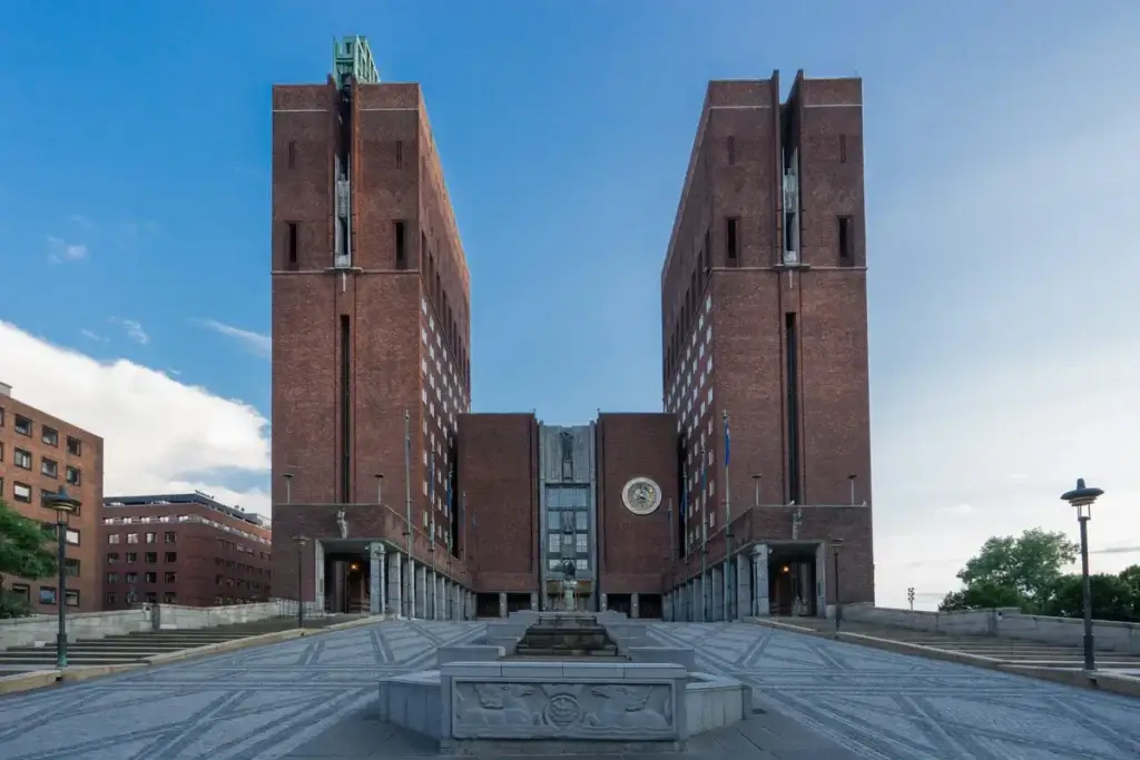 Oslo City Hall in Norway showcasing its iconic brick architecture under blue skies, a famous tourist attraction for Scandinavia travel.