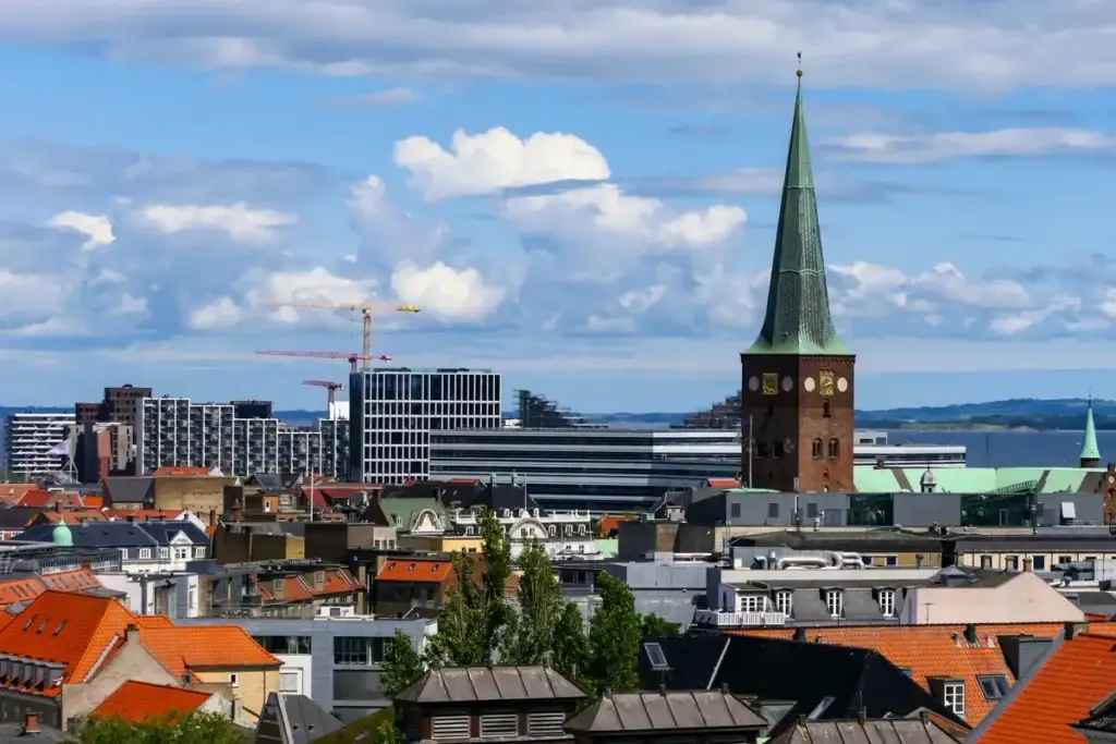 Panoramic view of Aarhus with Aarhus Cathedral prominent among modern and traditional buildings, showcasing Danish architecture and urban landscape.