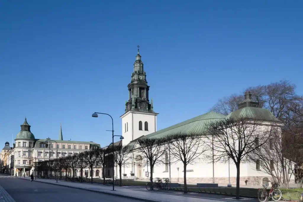 Church of Saint Lars in Linkoping, Sweden, showing the historic architecture and serene surroundings under a bright blue sky.