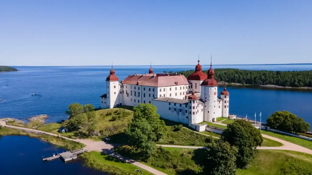 Aerial view of Lacko Castle on the shores of Lake Vanern under blue sky, popular historical attraction in Sweden for Scandinavia Private Tours.