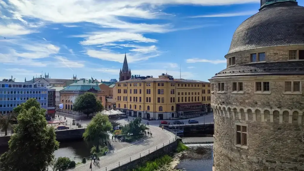 Panoramic view of Orebro, Sweden, showing the historic city center with the church spire, riverfront, and traditional architecture from the castle viewpoint.