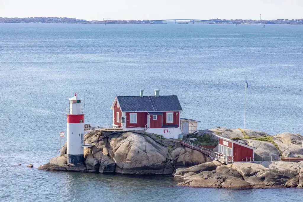 Gefveskar lighthouse situated on rocky outcrop in Gothenburg's archipelago, featuring scenic views of the surrounding blue waters and distant shoreline, Sweden, Europe.