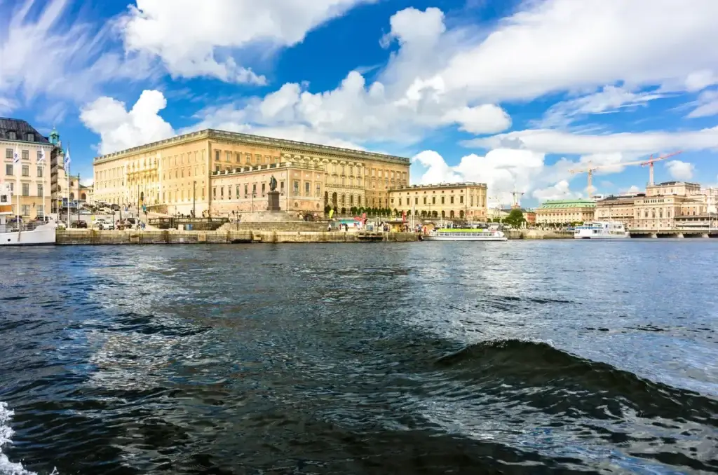 View of Stockholm Royal Palace in Sweden from the water, showcasing the grand architecture and bustling waterfront.