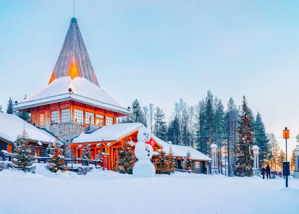 Snowman in front of Santa Office at Santa Claus Village, Rovaniemi Finland, showcasing a scenic snowy landscape with festive decorations and a charming wooden building.
