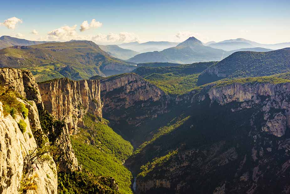 Breathtaking view of the Verdon Gorge in France, showcasing steep cliffs and lush green valleys under a clear sky