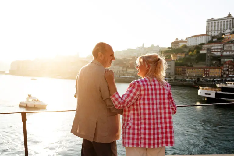 Senior couple enjoying a private tour with a scenic view of the Douro River and historic Ribeira district in Porto, Portugal at sunset