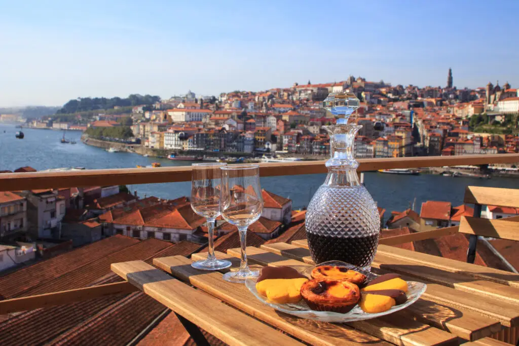 Scenic view of Porto Portugal with wine and traditional Portuguese desserts overlooking the Douro River and historic city rooftops