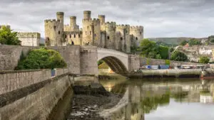 Historic Conwy Castle and bridge reflected in the River Conwy, Wales, showcasing medieval architecture and scenic landscape for European private tours