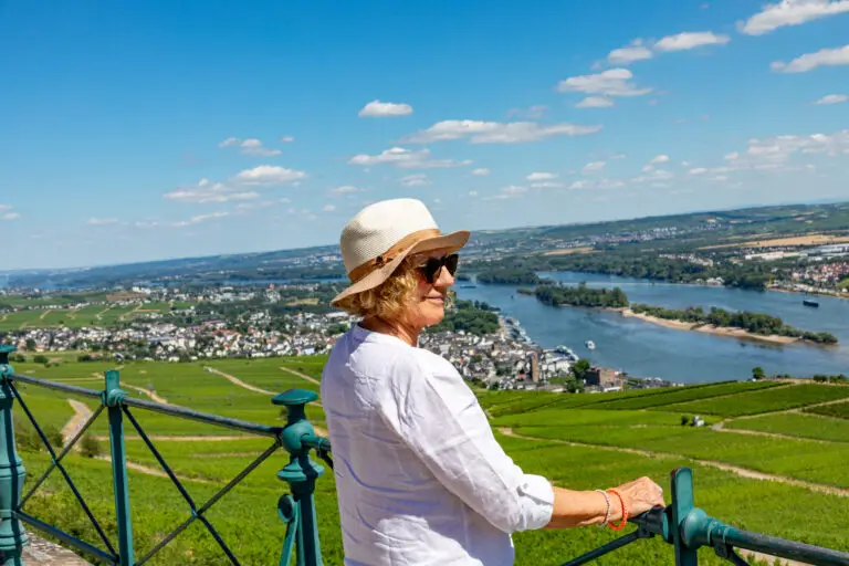 Woman enjoying panoramic view of the Rhine River Valley from the Niederwald Monument in Rüdesheim, Germany on a sunny day during a Europe private tour