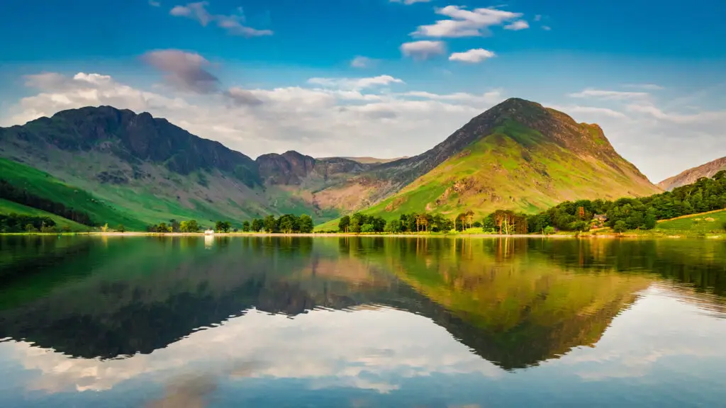 Scenic view of mountains reflected in a calm lake in the Lake District, England, popular destination for nature tours and private sightseeing in the UK