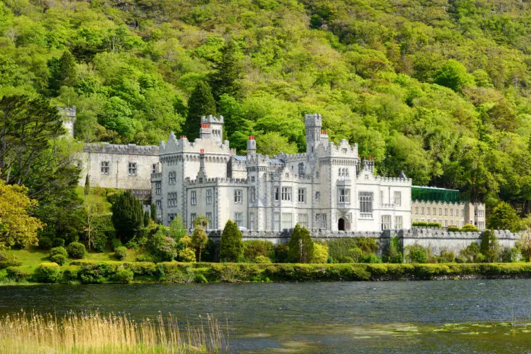Kylemore Abbey Benedictine monastery and historic castle reflected in a lake surrounded by lush green hills in Connemara Ireland