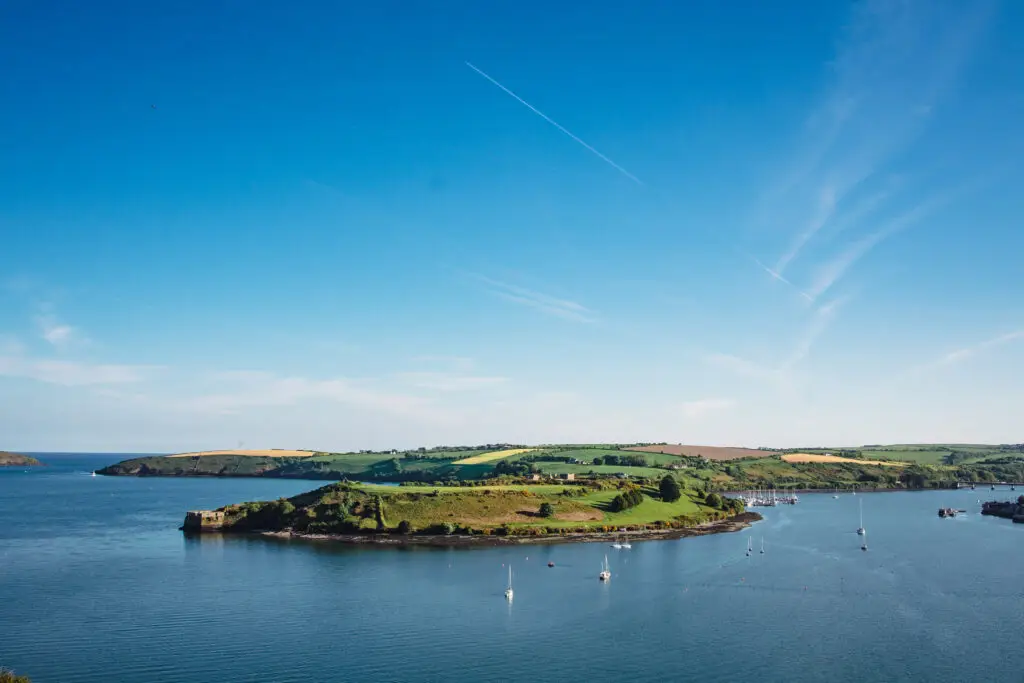 Scenic view of James Fort and Kinsale Harbour in County Cork, Ireland with sailboats on the water and lush green hills under a clear blue sky