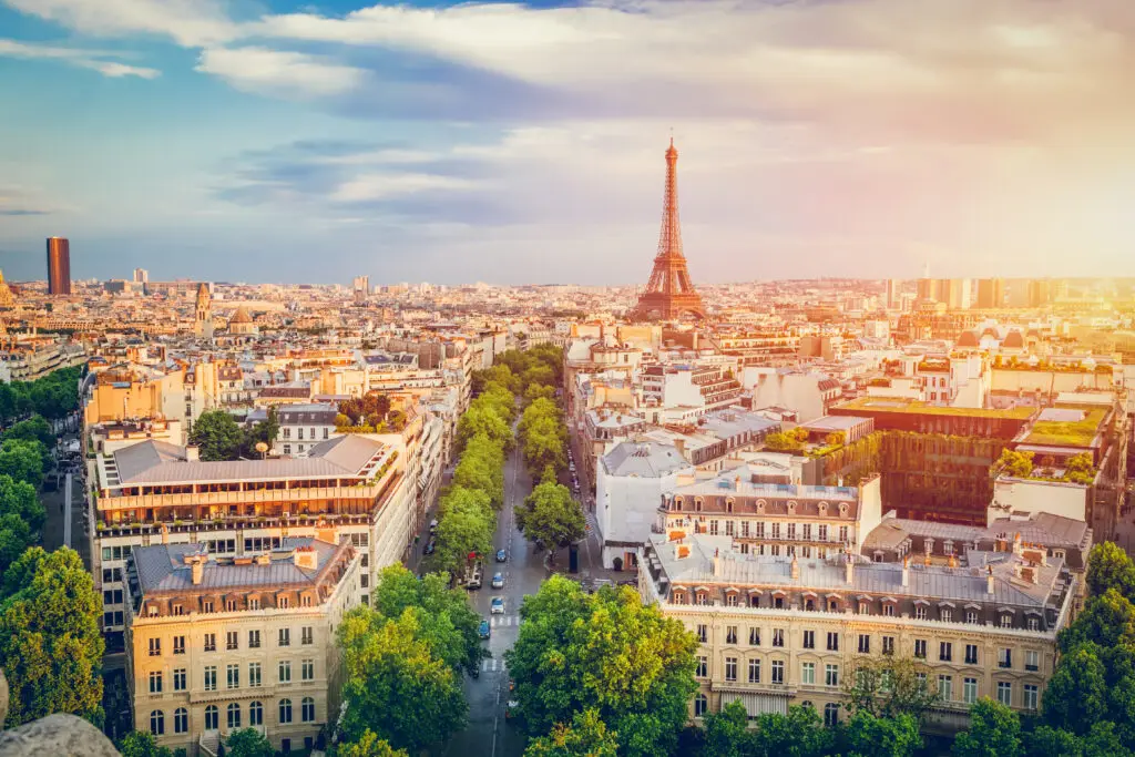 Panoramic view of Paris, France at sunset featuring the Eiffel Tower and Haussmann-style buildings, ideal for Europe private tours and Paris sightseeing experiences