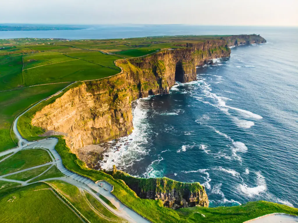 Aerial view of the Cliffs of Moher in County Clare, Ireland, showcasing dramatic sea cliffs, Atlantic Ocean waves, and scenic walking trails popular with tourists