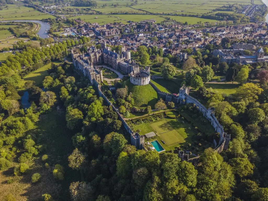Aerial view of Arundel Castle and gardens surrounded by lush countryside in Arundel, England, a popular historic tourist attraction in West Sussex