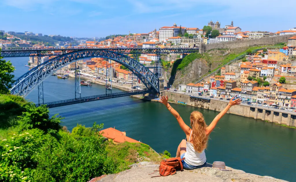 Woman tourist enjoying scenic view of Dom Luís I Bridge and old town of Porto Portugal during private Europe tour travel experience