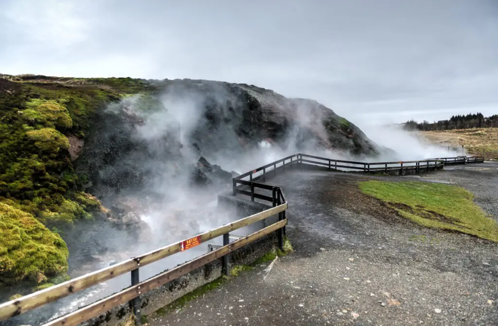 Deildartunguhver Geothermal Spring in Iceland with steam rising from hot springs and moss-covered rocks, a famous natural attraction visited on European private tours