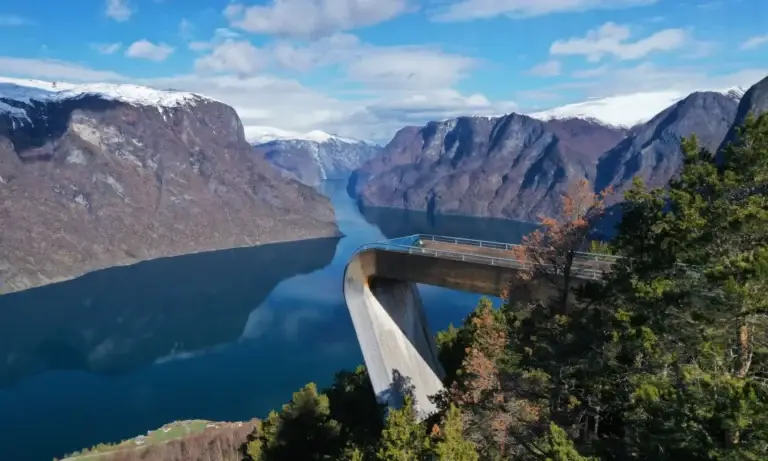 Stegastein viewpoint overlooking Aurlandsfjord surrounded by snow-capped mountains and deep blue water in Norway, a stunning Scandinavian travel destination