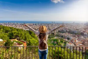 Tourist enjoying panoramic view of Barcelona Spain skyline from viewpoint with Mediterranean Sea in background