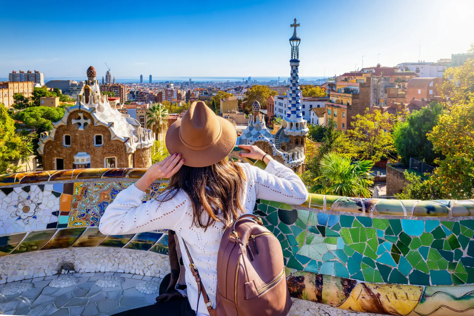 Tourist enjoying the view of colorful mosaic architecture at Park Güell in Barcelona, Spain