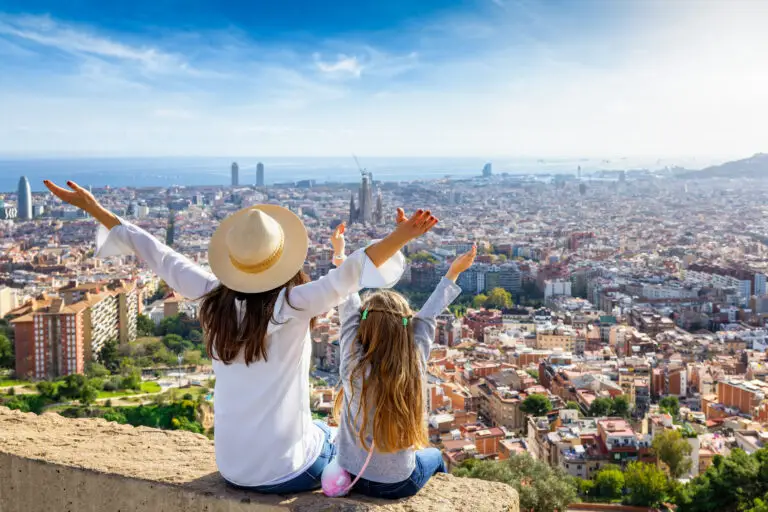 Tourists enjoying panoramic view of Barcelona Spain with famous city landmarks and Mediterranean Sea in the background