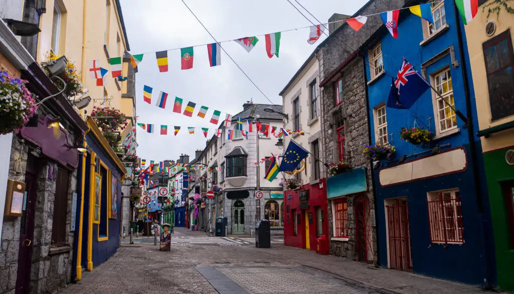 Colorful street with flags and historic buildings in Galway, Ireland, showcasing vibrant local architecture and European charm