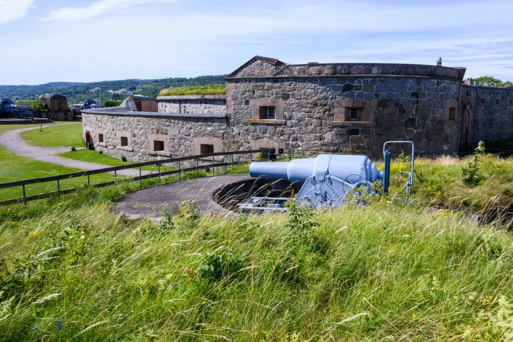 Historic Oscarsborg Fortress with coastal defense cannon and stone walls surrounded by greenery in the Oslofjord, Norway