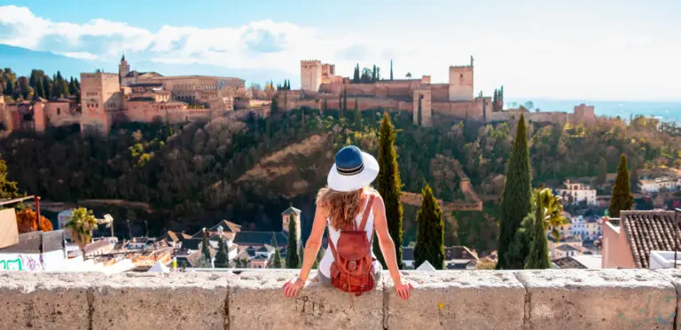 Tourist enjoying panoramic view of the Alhambra Palace in Granada, Spain on a sunny day
