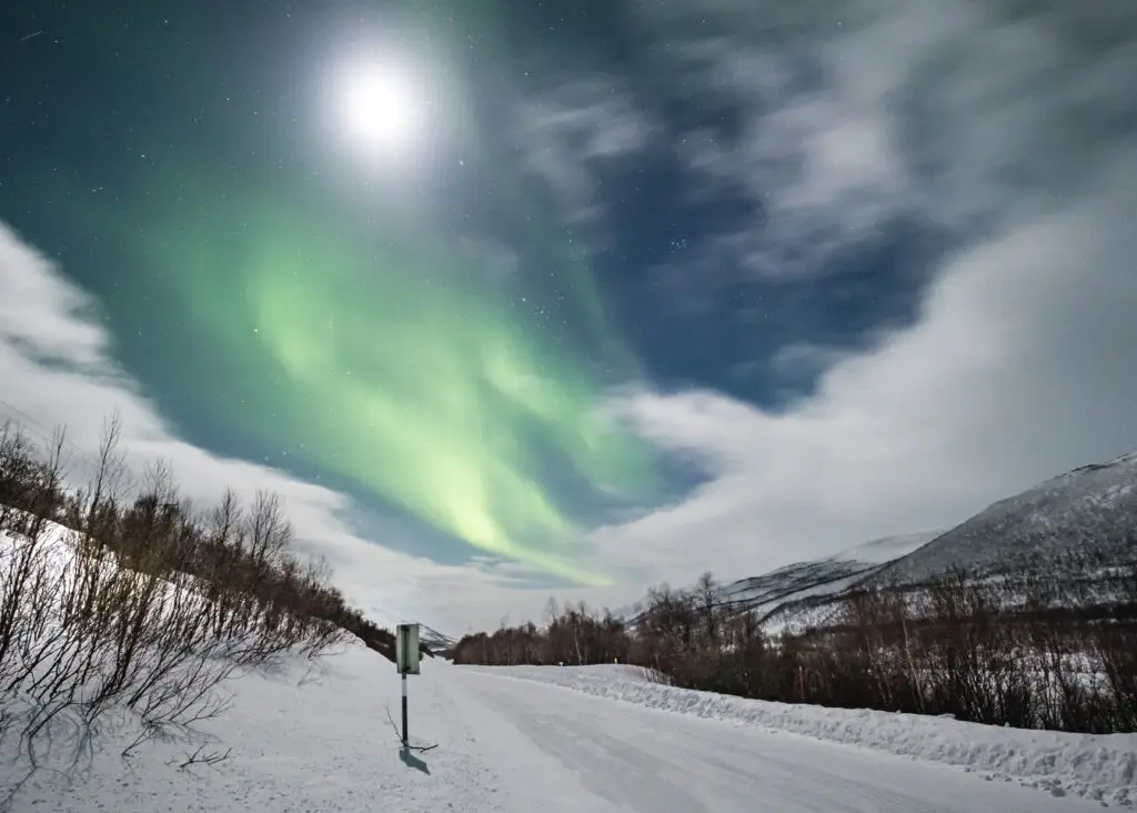 Aurora Borealis illuminating the night sky over snowy winter landscape near Utsjoki, Finland
