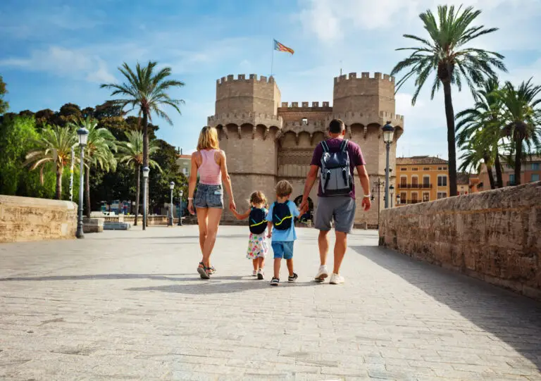 Family walking toward Torres de Serranos landmark in Valencia Spain on a sunny day during a private city tour