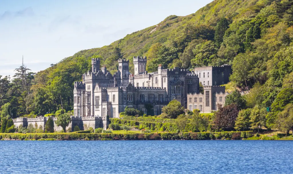 Kylemore Abbey Benedictine monastery in Connemara Ireland surrounded by lush green hills and reflected in the tranquil lake
