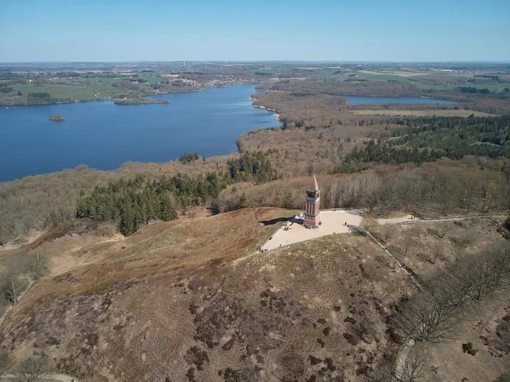 Aerial view of the mountain of Heaven between lakes and forests in Denmark featuring the historic Himmelbjerget tower, a popular European tourist attraction