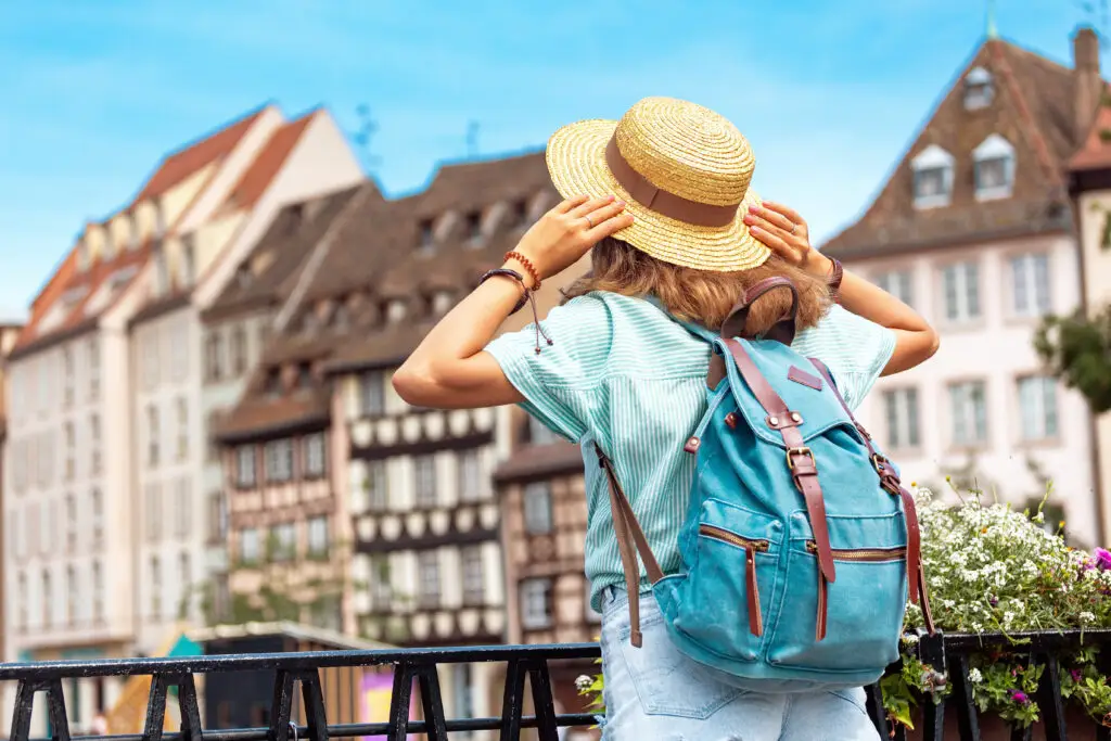 Tourist exploring the historic old town of Strasbourg France with traditional half-timbered houses in the background