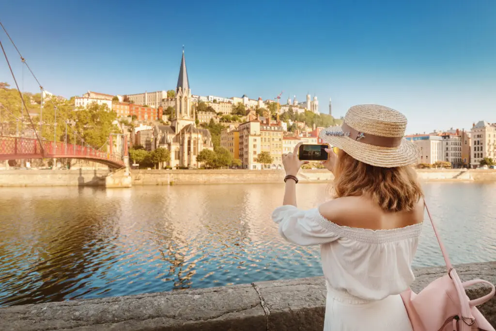 Tourist taking a photo of the Saône River and historic architecture in Lyon France during a summer private tour