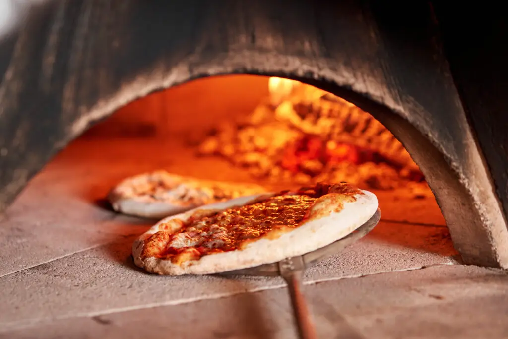 Authentic Neapolitan pizza baking in a traditional wood-fired oven in Naples, Italy
