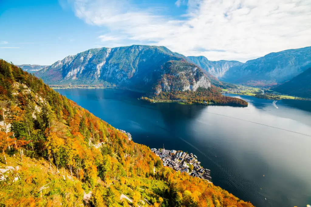Aerial view of Hallstatt village and Hallstätter See lake from the Skywalk in Austria, surrounded by autumn mountains and colorful forest scenery