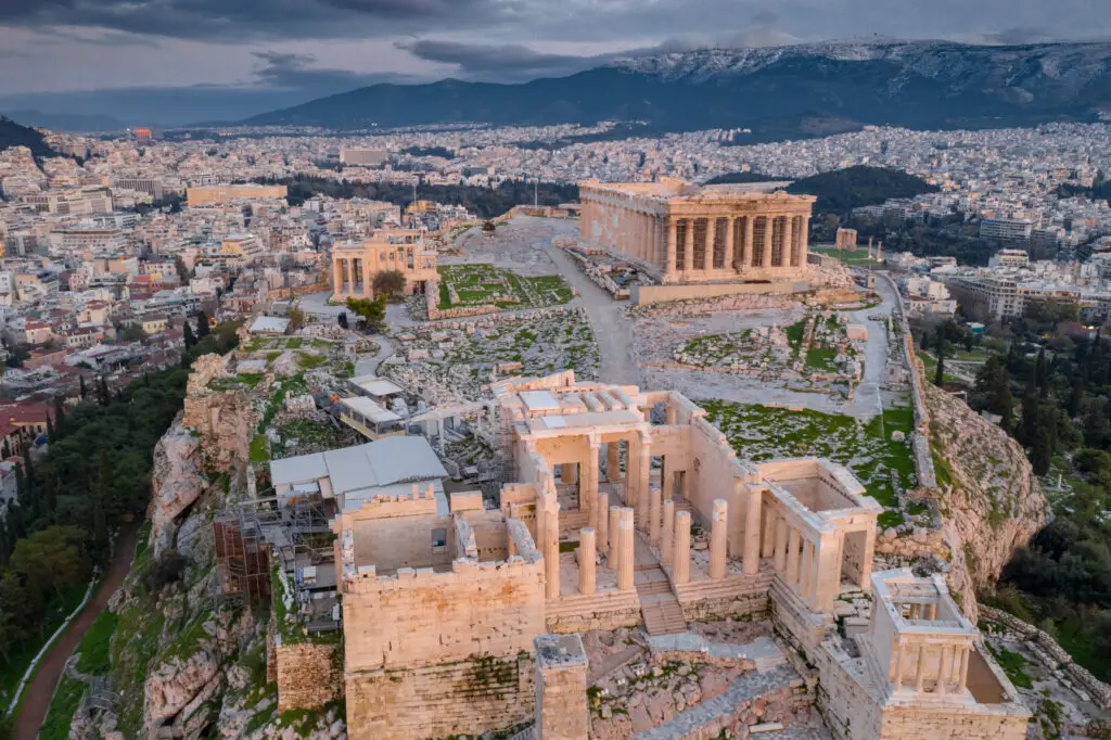 Aerial view of the Acropolis of Athens in Greece showcasing the Parthenon and ancient ruins with the city of Athens and mountains in the background