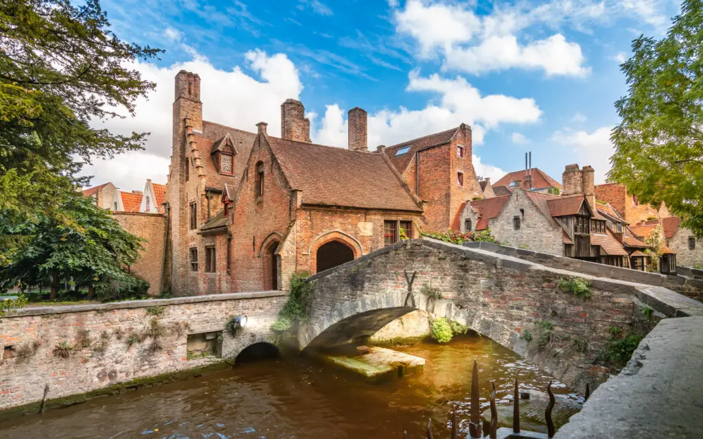 Historic stone bridge over canal surrounded by medieval brick buildings in Bruges, Belgium, a popular European travel destination