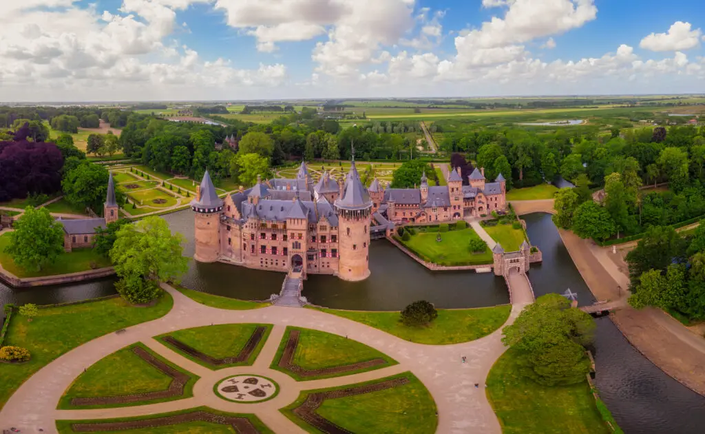 Aerial view of De Haar Castle in Utrecht, Netherlands surrounded by gardens and water, a popular European tourist attraction and historic landmark