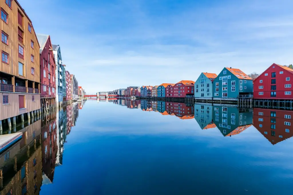 Colorful wooden houses reflecting on the Nidelva River in Trondheim, Norway, a popular travel destination for European private tours