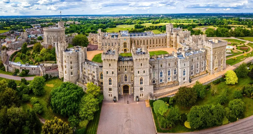 Aerial view of Windsor Castle in England surrounded by lush greenery, showcasing historic architecture and ideal for promoting UK private tours and European travel experiences
