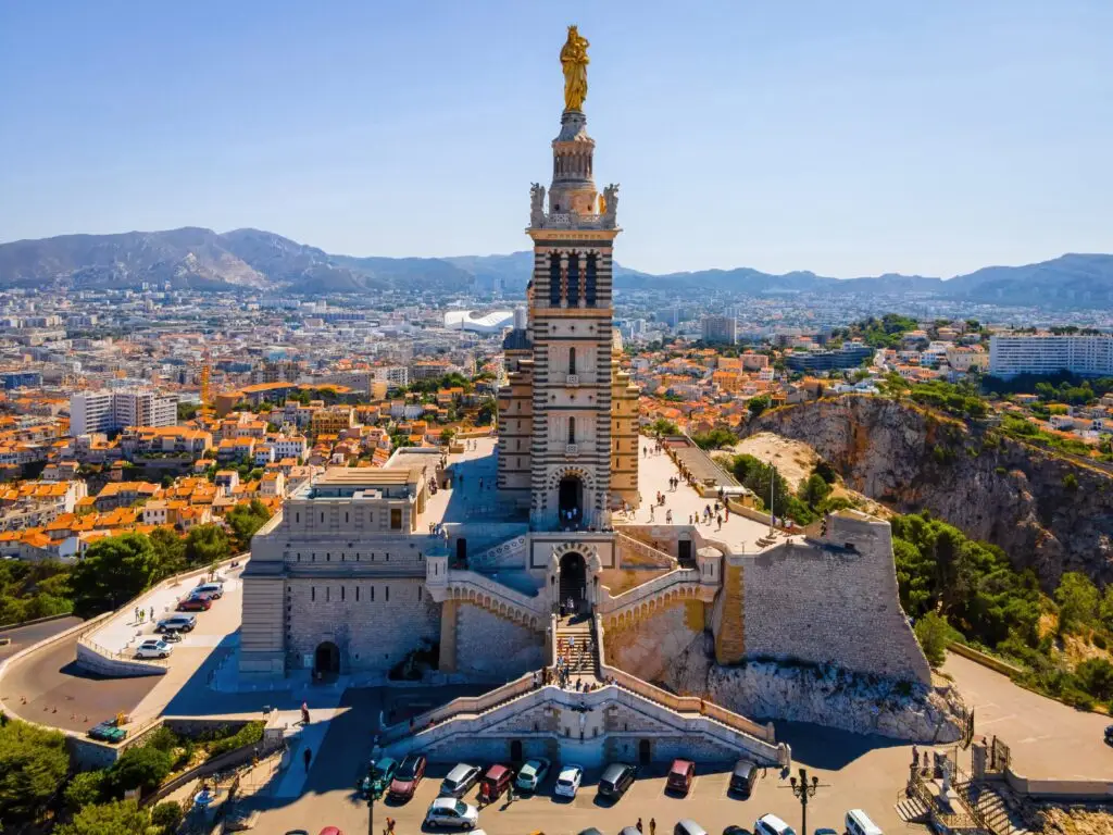 Aerial view of Notre-Dame de la Garde Basilica overlooking the city and harbor of Marseille, France, a popular sightseeing destination on private tours in Provence.