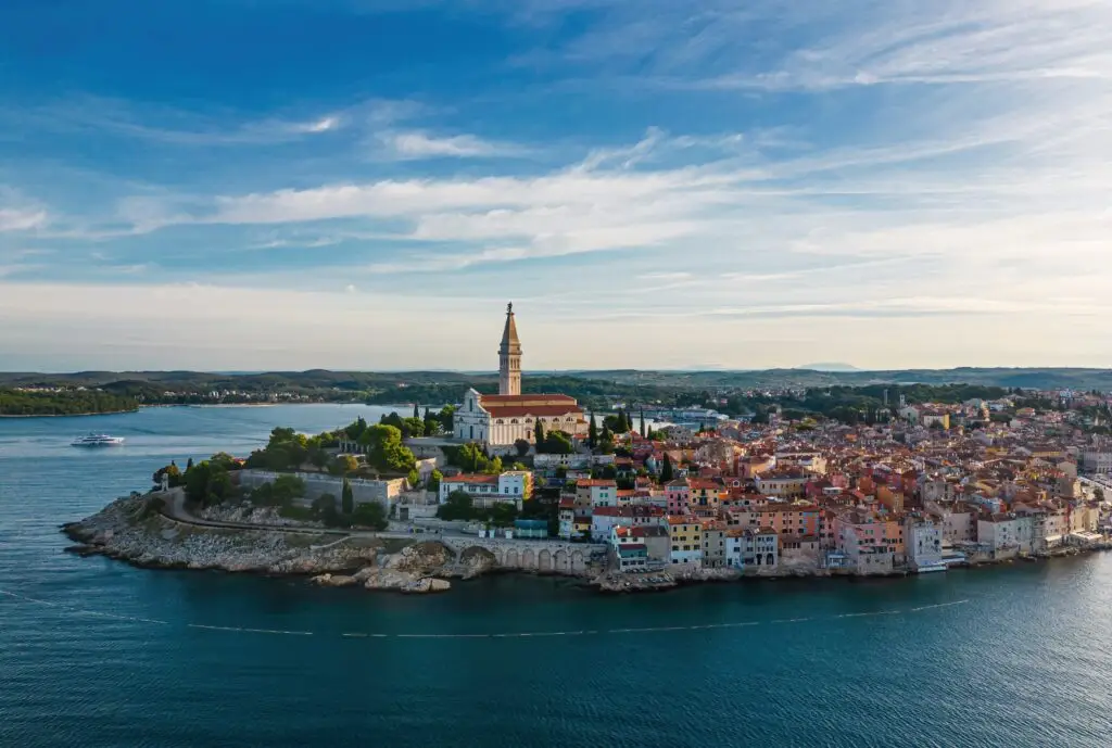 Aerial view of Rovinj, Croatia showcasing the historic old town, colorful coastal buildings, and St. Euphemia Church surrounded by the Adriatic Sea