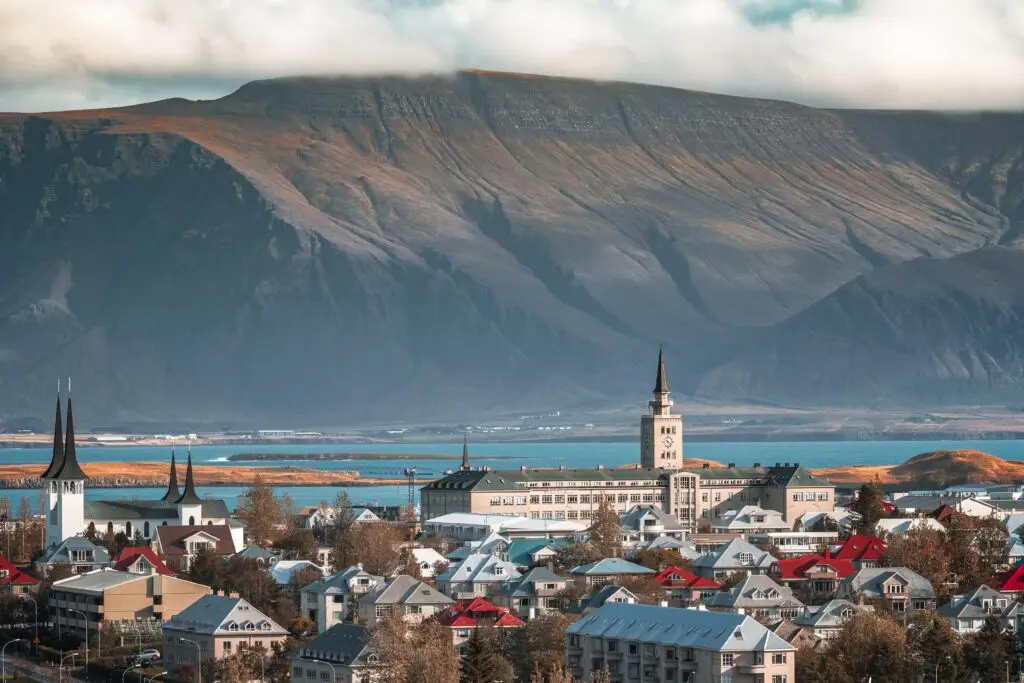 Scenic view of Reykjavík Iceland with colorful rooftops, historic churches, and Esja Mountain in the background captured on a clear day