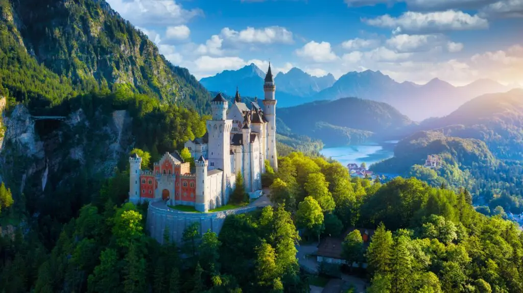 Neuschwanstein Castle in Bavaria Germany surrounded by lush green forests and mountain scenery under a bright blue sky perfect destination for European private tours