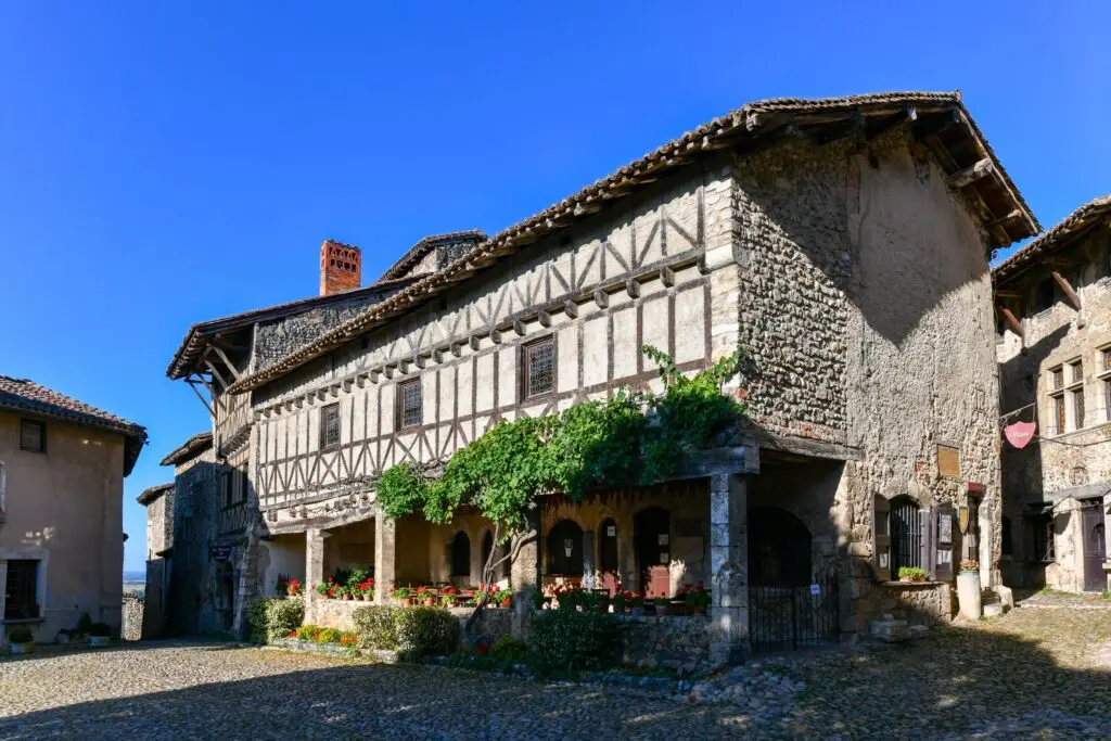 Medieval stone buildings and cobblestone streets in the historic village of Pérouges, France, a popular tourist destination known for its preserved architecture and old-world charm