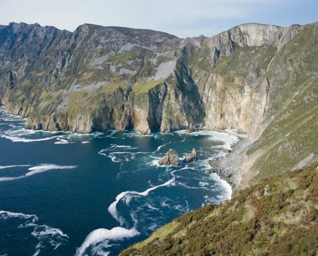 Dramatic view of Slieve League Cliffs rising 300 meters above the Atlantic Ocean in County Donegal, Ulster, Ireland showcasing rugged coastline and vibrant blue sea