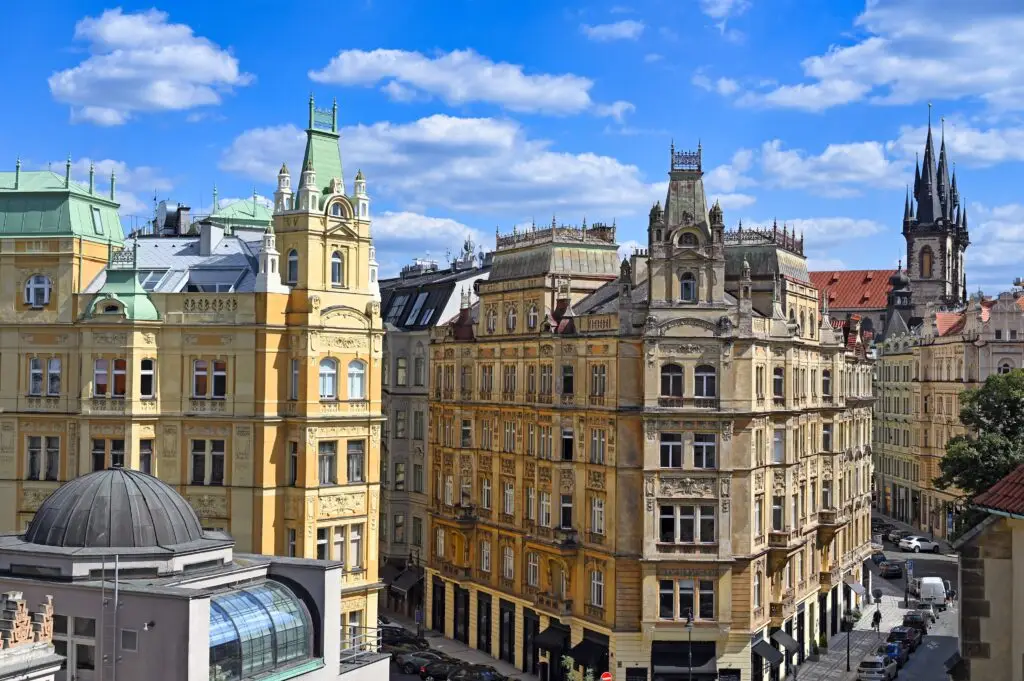 Historic buildings and cobblestone street in the Jewish Quarter of Prague, Czech Republic, showcasing classic European architecture under a bright blue sky